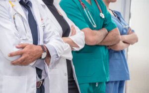 A group of doctors and nurses standing and working together in a nursing home.