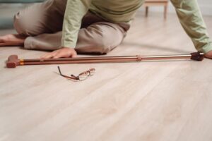 Asian senior man falling on the ground with a walker in his living room at home. Elderly mature male experiencing an accident or heart attack, requiring emergency help and support.