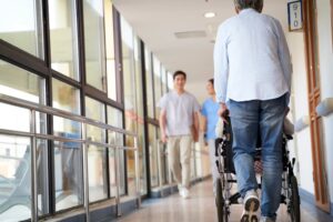 Residents and staff walking in the hallway of an Asian nursing home.