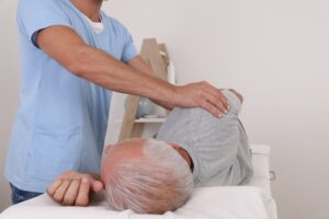 Chiropractic and osteopathy treatment for back pain relief. Physiotherapy for an elderly male patient, aiding in sport injury recovery.