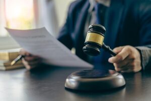 Lawyer with contract documents, gavel, and scales of justice in close-up.