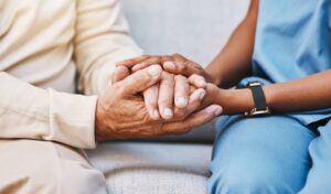 A nurse offers empathetic hands-on support to a senior patient, emphasizing trust, safety, and compassionate healthcare consulting.