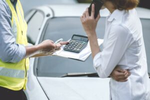 Car claim agent officer showing service cost to women driver