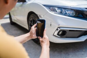 Man taking photos of damaged car after accident