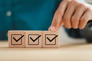 Man hand putting wooden cube with checklist icon