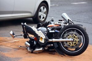 a motorcycle lying on road after accident with a car